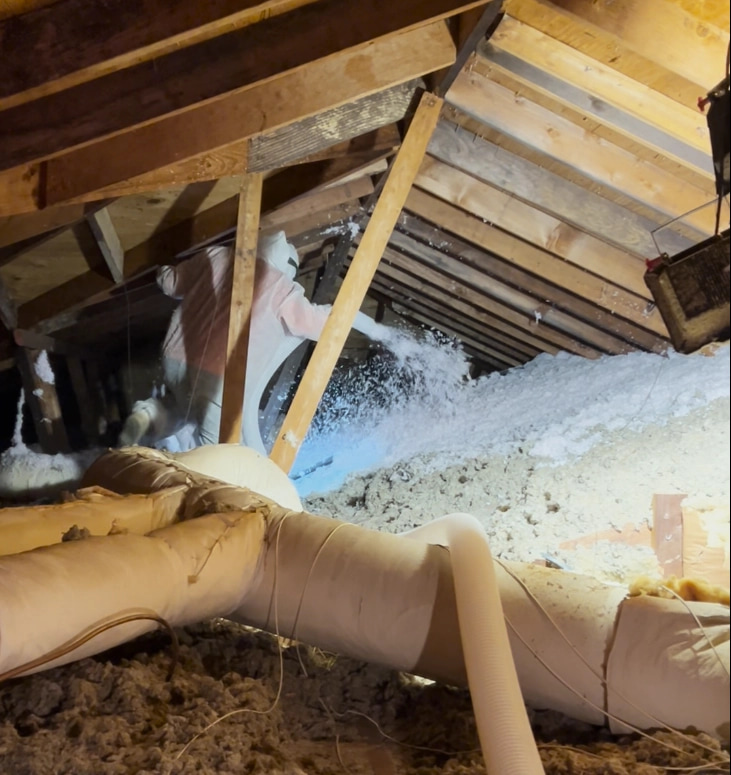 Blown-in fiberglass insulation being installed in a residential attic